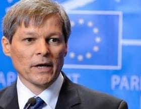 A man in a suit speaking at a press conference with a European Parliament backdrop. - Olive Oil Times