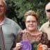 Three individuals posing together, holding various awards and ribbons in their hands. - Olive Oil Times