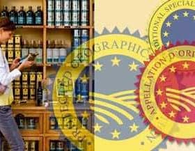 Individual standing in front of a shelf filled with olive oil bottles while using a smartphone. - Olive Oil Times