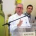 A chef in a white coat speaking at a podium with a microphone during an event. - Olive Oil Times