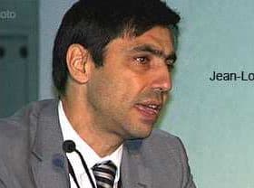 Jean-Louis Barjol speaking at a conference, wearing a suit and tie. - Olive Oil Times