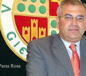 Portrait of Manuel Paras Rosa standing in front of a coat of arms emblem. - Olive Oil Times