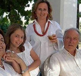 Four individuals, including two adults and two children, posing together in casual attire outdoors. - Olive Oil Times