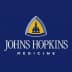 Logo of Johns Hopkins Medicine featuring a blue background with a yellow emblem and text. - Olive Oil Times
