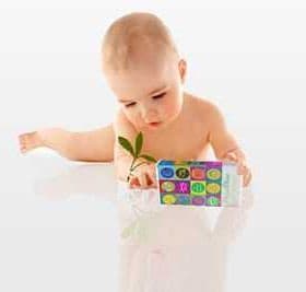 Infant exploring a colorful toy with numbers and letters while holding a small plant. - Olive Oil Times