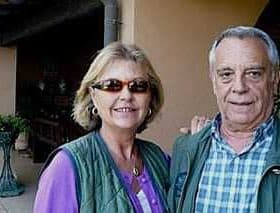 A man and a woman posing for a photo outdoors, both wearing sunglasses and casual attire. - Olive Oil Times