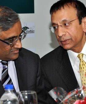 Two men in business attire engaged in a conversation at a formal event. - Olive Oil Times