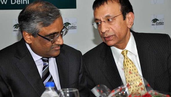 Two men in business attire engaged in a conversation at a formal event. - Olive Oil Times