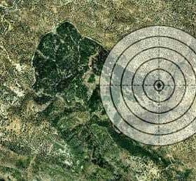 Satellite view of a landscape with a circular target overlay in the center. - Olive Oil Times