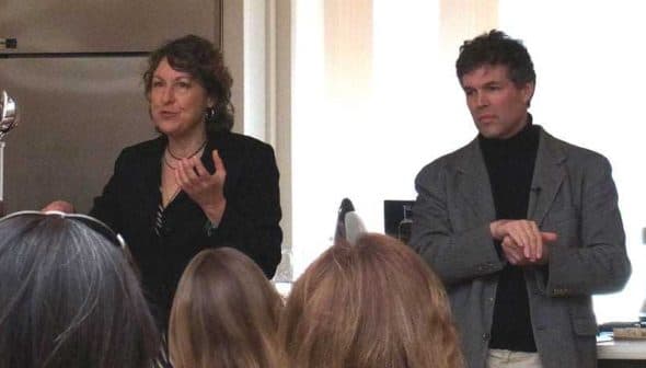 Two presenters speaking during a cooking demonstration in a kitchen setting. - Olive Oil Times
