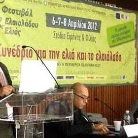 Speaker presenting at a conference about olive oil and olive cultivation with an audience in attendance. - Olive Oil Times