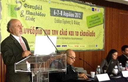 Speaker presenting at a conference about olive oil and olive cultivation with an audience in attendance. - Olive Oil Times