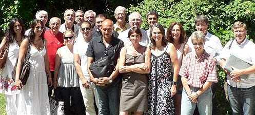 Group of individuals posing together outdoors, smiling and dressed in casual attire. - Olive Oil Times