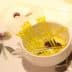 A small white bowl containing yellow oil and several clear pipettes arranged inside it. - Olive Oil Times