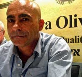 Two men seated at a conference table with a sign that reads 'Terra Olivo'. - Olive Oil Times