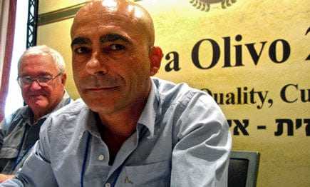 Two men seated at a conference table with a sign that reads 'Terra Olivo'. - Olive Oil Times