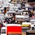 A congested traffic scene with various vehicles and people in an urban setting. - Olive Oil Times