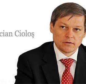 Dacian Cioloș, a man in a suit with a red tie, seated and looking serious. - Olive Oil Times