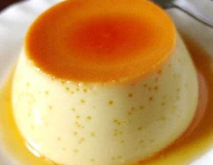 A smooth custard dessert topped with a layer of caramel sauce on a white plate. - Olive Oil Times