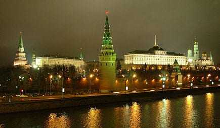 Night view of the Moscow Kremlin with illuminated towers and buildings along the river. - Olive Oil Times