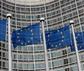 Multiple European Union flags waving in front of the European Commission building in Brussels. - Olive Oil Times