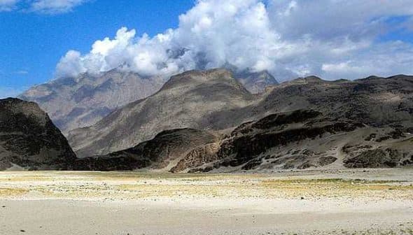 Mountain landscape in Pakistan featuring rocky terrain and clouds in the sky. - Olive Oil Times