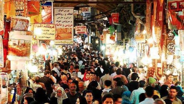A busy market in Tehran filled with people and various stalls displaying goods. - Olive Oil Times