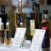 Assorted bottles of olive oil with labels displayed on a table at an event. - Olive Oil Times