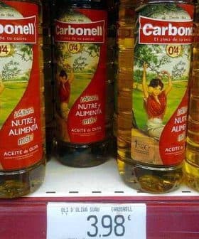 Three bottles of Carbonell olive oil displayed on a store shelf with a price tag below. - Olive Oil Times
