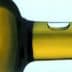 Close-up view of the neck of an olive oil bottle with a droplet of oil on the surface. - Olive Oil Times