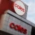 Signage of Coles supermarket featuring the logo and name in red on a building facade. - Olive Oil Times