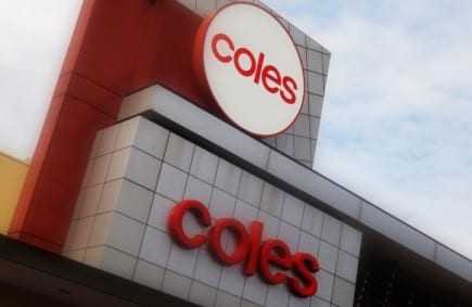 Signage of Coles supermarket featuring the logo and name in red on a building facade. - Olive Oil Times