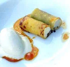 Two rolled pastries filled with cream served alongside a scoop of ice cream and sauce. - Olive Oil Times