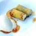 Two rolled pastries filled with cream served alongside a scoop of ice cream and sauce. - Olive Oil Times