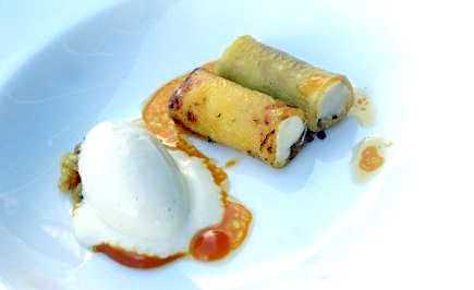 Two rolled pastries filled with cream served alongside a scoop of ice cream and sauce. - Olive Oil Times