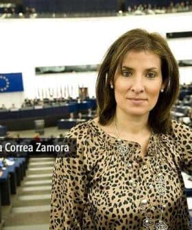 Maria Auxiliadora Correa Zamora posing in the European Parliament chamber with a leopard print top. - Olive Oil Times