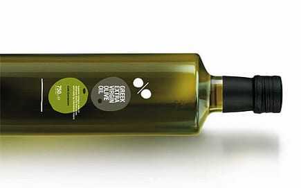 A green glass bottle of extra virgin olive oil with a label and a black cap. - Olive Oil Times