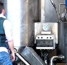 Civil Guard officer in a blue vest examining industrial equipment in a facility. - Olive Oil Times