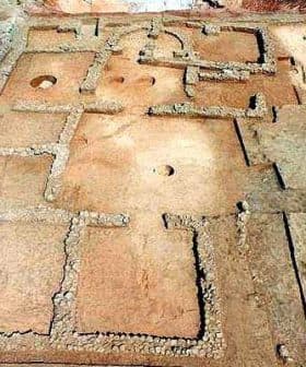 Aerial view of an archaeological site featuring stone foundations and layout of ancient structures. - Olive Oil Times