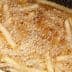 Fried potato strips bubbling in hot oil during the cooking process. - Olive Oil Times