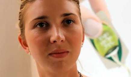 Close-up portrait of a woman with light hair and earrings, looking directly at the camera. - Olive Oil Times