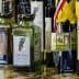 Various bottles of olive oil displayed with medals and awards attached to them. - Olive Oil Times