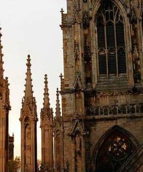 Gothic cathedral with spires and intricate stonework under a sunset sky. - Olive Oil Times