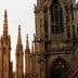 Gothic cathedral with spires and intricate stonework under a sunset sky. - Olive Oil Times