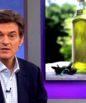 Dr. Oz speaking with olive oil bottles displayed in the background during a television segment. - Olive Oil Times