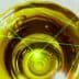 Close-up view of olive oil in a circular container with laser light effects overlaying the surface. - Olive Oil Times