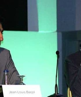 Two men engaged in a panel discussion, Jean-Louis Bargal on the left and Tom Mueller on the right. - Olive Oil Times