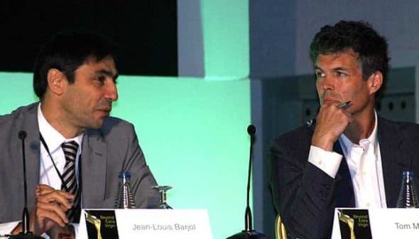 Two men engaged in a panel discussion, Jean-Louis Bargal on the left and Tom Mueller on the right. - Olive Oil Times