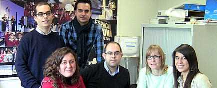 A group of six individuals posing together in an office environment, with various expressions and attire. - Olive Oil Times