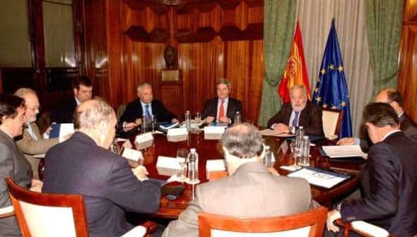 Group of officials seated around a large conference table during a meeting. - Olive Oil Times